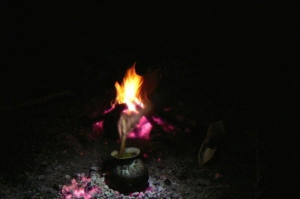 Jim Robertson stirring a wild soup of handpicked stinging nettles, wild mustard, wild peas and more in his handmade ceramic pot over a fire he started the aboriginal way.  