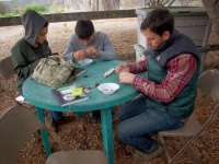 Crafters making seed necklaces 